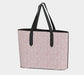 Tote bag with pink floral pattern and black handles on a light gray background